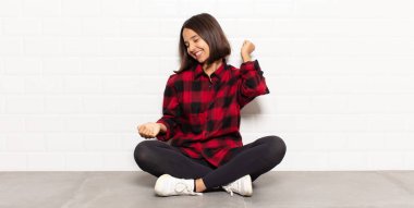 İspanyol kadın gülümsüyor, kaygısız hissediyor, rahat ve mutlu, dans ediyor ve müzik dinliyor, bir partide eğleniyor.