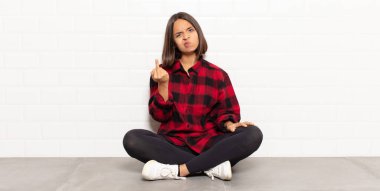 İspanyol kadın kızgın, sinirli, asi ve agresif hissediyor, orta parmağını sallıyor, karşı koyuyor.