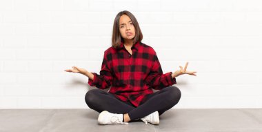 hispanic woman feeling clueless and confused, having no idea, absolutely puzzled with a dumb or foolish look