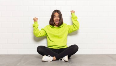 İspanyol kadın muzaffer bir şekilde bağırıyor, heyecanlı, mutlu ve şaşırmış görünüyor, kutlama yapıyor.