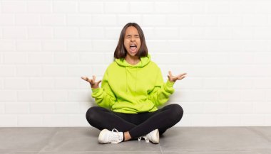 İspanyol kadın öfkeyle bağırıyor, stresli hissediyor ve ellerini havaya kaldırıp neden ben diye bağırıyor.