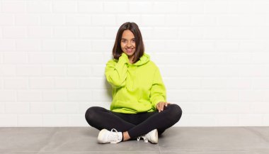 İspanyol kadın neşeli ve kendinden emin bir şekilde gülüyor. Sıradan, mutlu, dostane bir gülümsemeyle.