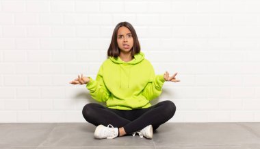 İspanyol kadın bilgisiz ve kafası karışık, hangi seçeneği seçeceğinden emin değil, merak ediyor.