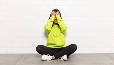 İspanyol kadın stresli ve endişeli, depresif ve hayal kırıklığına uğramış hissediyor, iki elini de başa kaldırıyor.