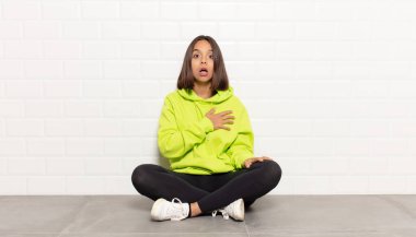 İspanyol kadın şaşkın ve şaşırmış hissediyor, gülümsüyor, el ele tutuşuyor, o olmaktan mutlu ya da minnettarlık gösteriyor.