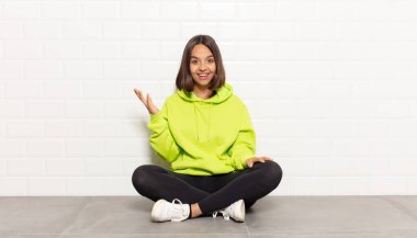 İspanyol kadın kendini mutlu, şaşırmış ve neşeli hissediyor. Pozitif bir tavırla gülümsüyor. Bir çözüm ya da fikir buluyor.