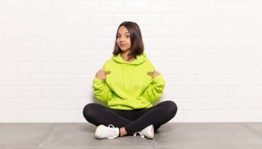 İspanyol kadın gururlu, pozitif ve iki eliyle göğsünü gösteren