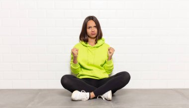 İspanyol kadın kendinden emin, sinirli, güçlü ve agresif görünüyor. Yumrukları boks pozisyonunda dövüşmeye hazır.