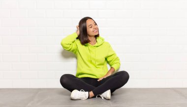 İspanyol kadın neşeli ve sıradan bir şekilde gülümsüyor, olumlu, mutlu ve kendinden emin bir bakışla yumruk yumruğa.