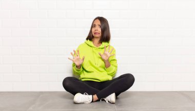 İspanyol kadın korkmuş, geri çekiliyor ve korku ve panik içinde bağırıyor, kabusa tepki veriyor.