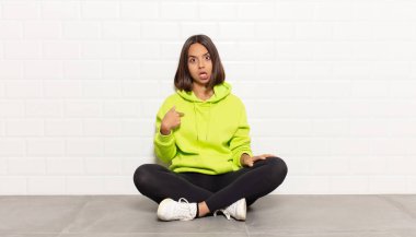 Hispanik kadın şaşkın, şaşkın ve güvensiz hissediyor, kendini gösterip kim olduğunu soruyor, ben mi??