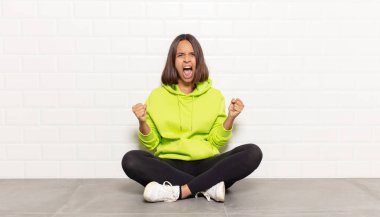 Öfkeli bir ifadeyle saldırganca bağıran İspanyol kadın mı yoksa başarıyı kutlayan yumruklarla mı?