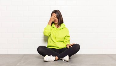 İspanyol kadın stresli, mutsuz ve hayal kırıklığına uğramış, alnına dokunuyor ve şiddetli baş ağrısı çekiyor.