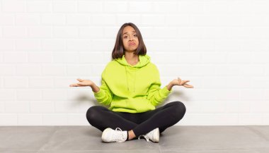 İspanyol kadın şaşkın ve şaşkın hissediyor, doğru cevap ya da karardan emin değil, bir seçim yapmaya çalışıyor.