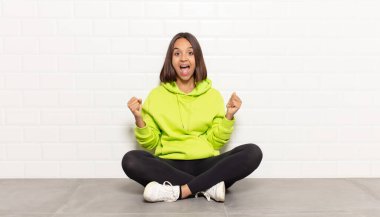 İspanyol kadın mutlu, pozitif ve başarılı hissediyor, zaferi, başarıları veya iyi şansı kutluyor.