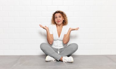 Orta yaşlı kadın şaşkın ve şaşkın hissediyor, şüpheci, farklı seçenekleri tartıyor veya komik bir ifadeyle seçiyor.