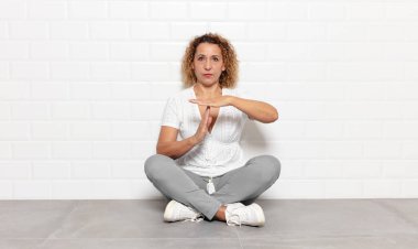 Orta yaşlı bir kadın ciddi, sert, kızgın ve canı sıkkın görünüyor.