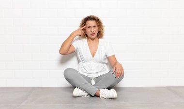 Orta yaşlı bir kadın kafası karışık ve şaşkın hissediyor. Deli, deli ya da aklını kaçırmış olduğunu gösteriyor.