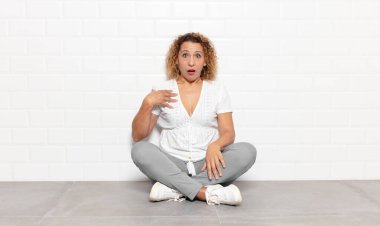 Orta yaşlı kadın şaşkın, şaşkın ve şaşırmış hissediyor, elleri göğsünde ve ağzı açık, kim olduğunu söylüyor, ben mi??