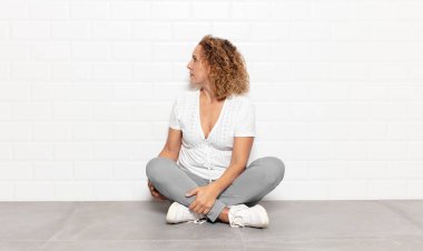 Profil görünümlü orta yaşlı kadın ileriyi kopyalamak istiyor, düşünüyor, hayal ediyor ya da hayal kuruyor.