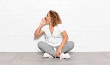 Orta yaşlı kadın profili, mutlu ve heyecanlı görünüyor, bağırıyor ve kenarda yer kopyalamak için arıyor.