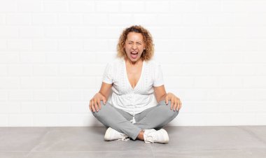 Orta yaşlı bir kadın agresif bir şekilde bağırıyor, sinirli, sinirli, öfkeli ya da sinirli görünüyor, hayır diye bağırıyor.