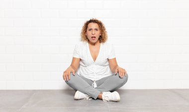 Orta yaşlı bir kadın şok olmuş, kızgın, sinirli ya da hayal kırıklığına uğramış, ağzı açık ve öfkeli görünüyor.