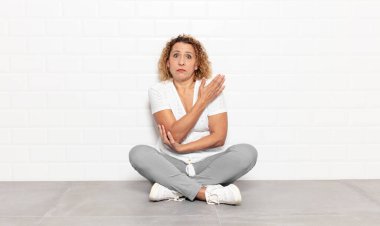 Orta yaşlı bir kadın kafası karışık ve bilgisiz, şüpheli bir açıklama ya da düşünceyi merak ediyor.