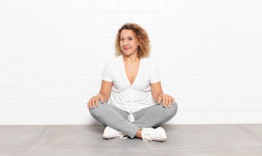 Orta yaşlı bir kadın mutlu ve arkadaş canlısı görünüyor, gülümsüyor ve sana olumlu bir tavırla göz kırpıyor.