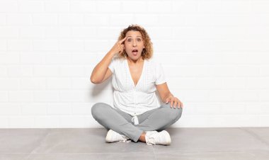 Orta yaşlı kadın şaşırmış, ağzı açık, şok olmuş, yeni bir düşünce, fikir ya da konsept keşfediyor.