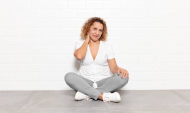 Orta yaşlı bir kadın neşeli ve kendinden emin bir şekilde gülüyor.