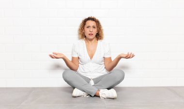 Orta yaşlı bir kadın bilgisiz ve kafası karışık, hangi seçeneği seçeceğinden emin değil, merak ediyor.