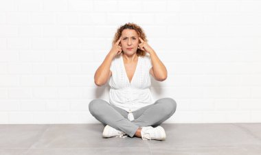 Orta yaşlı kadın odaklanmış ve bir fikir üzerinde kafa yoruyor, bir soruna ya da soruna bir çözüm hayal ediyor.