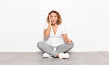 Orta yaşlı bir kadın ağzı açık bir şekilde yüz yüze inanmayarak şok olmuş ve hayrete düşmüş hissediyor.