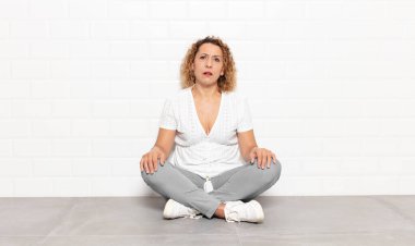 middle age woman feeling puzzled and confused, with a dumb, stunned expression looking at something unexpected