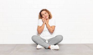 Orta yaşlı bir kadın aşık ve sevimli görünüyor. Sevimli ve mutlu. Romantik bir şekilde gülümsüyor.