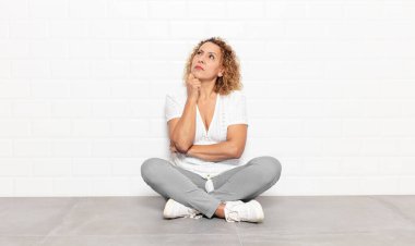 Orta yaşlı kadın düşünüyor, kuşkulu ve şaşkın hissediyor, farklı seçeneklerle, hangi kararı vereceğini merak ediyor.