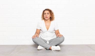 Orta yaşlı bir kadın, hangi seçeneği seçeceğine karar veremediğini ve sorunu çözmeye çalıştığını düşünüyor.