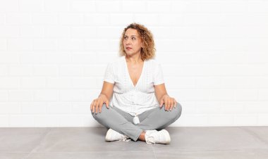 Orta yaşlı kadın şaşkın, mutlu, şaşkın ve şaşırmış hissediyor, ağzı açık bir şekilde yana bakıyor.