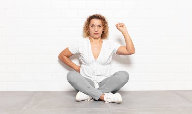 Orta yaşlı kadın ciddi, güçlü ve isyankar hissediyor, yumruğunu kaldırıyor, protesto ediyor ya da devrim için savaşıyor.