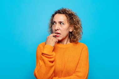 Şaşırmış, gergin, endişeli ya da korkmuş bakışları olan orta yaşlı bir kadın fotokopi alanına doğru bakıyor.