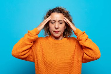 Orta yaşlı bir kadın konsantre olmuş, düşünceli ve ilham verici, beyin fırtınası yapıyor ve hayal kuruyor.