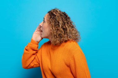 Orta yaşlı kadın profili, mutlu ve heyecanlı görünüyor, bağırıyor ve kenarda yer kopyalamak için arıyor.