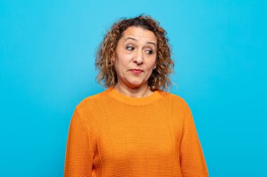 Orta yaşlı kadın merak ediyor, mutlu düşünceler ve fikirler düşünüyor, hayal kuruyor, kenarda yer arıyor.