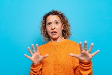 Orta yaşlı bir kadın korku ve panik içinde geri çekilip çığlık atıyor ve kabusa tepki veriyor.