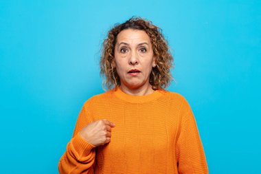 Orta yaşlı bir kadın şaşkın, şaşkın ve güvensiz hissediyor. Kendini gösterip kim olduğunu soruyor, ben mi??