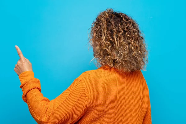 Orta yaşlı kadın dikey görünüm ve kopyalama alanı üzerinde duran ve nesneyi işaret eden