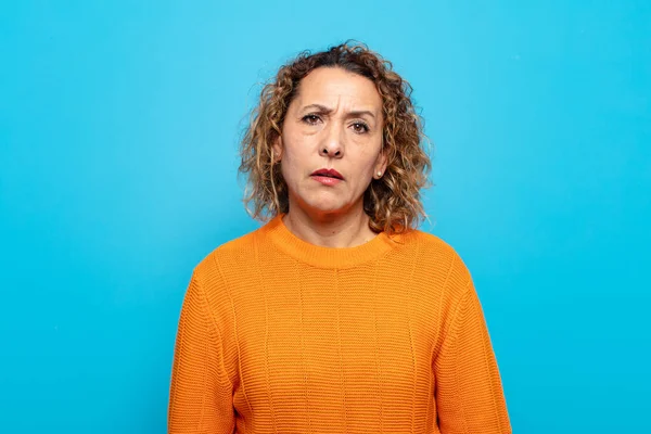 middle age woman feeling puzzled and confused, with a dumb, stunned expression looking at something unexpected