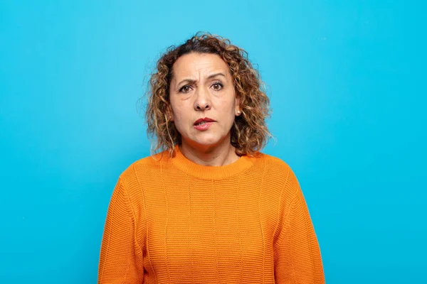 Orta yaşlı bir kadın, hangi seçeneği seçeceğine karar veremediğini ve sorunu çözmeye çalıştığını düşünüyor.