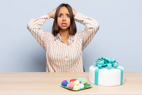 hispanic woman feeling stressed, worried, anxious or scared, with hands on head, panicking at mistake